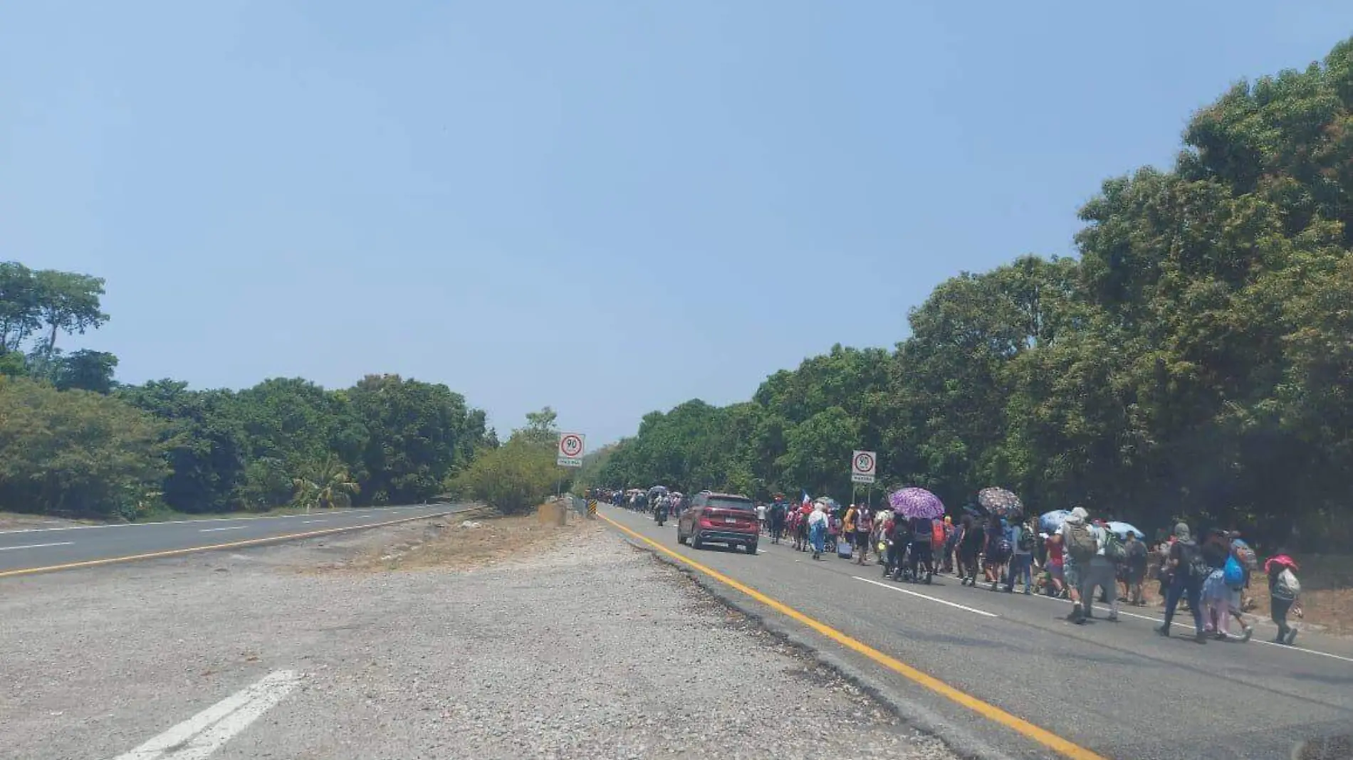 migrantes caminando en la costera